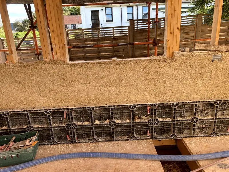 A long run of cast hempcrete with shuttering at the base, ready for the next lift