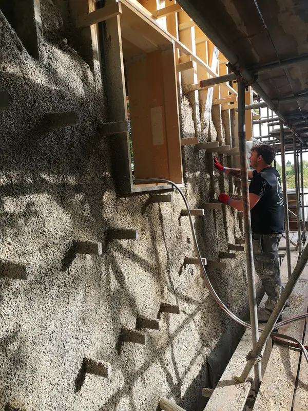 Freshly sprayed hempcrete wall with timber fixings protruding for the cladding battens