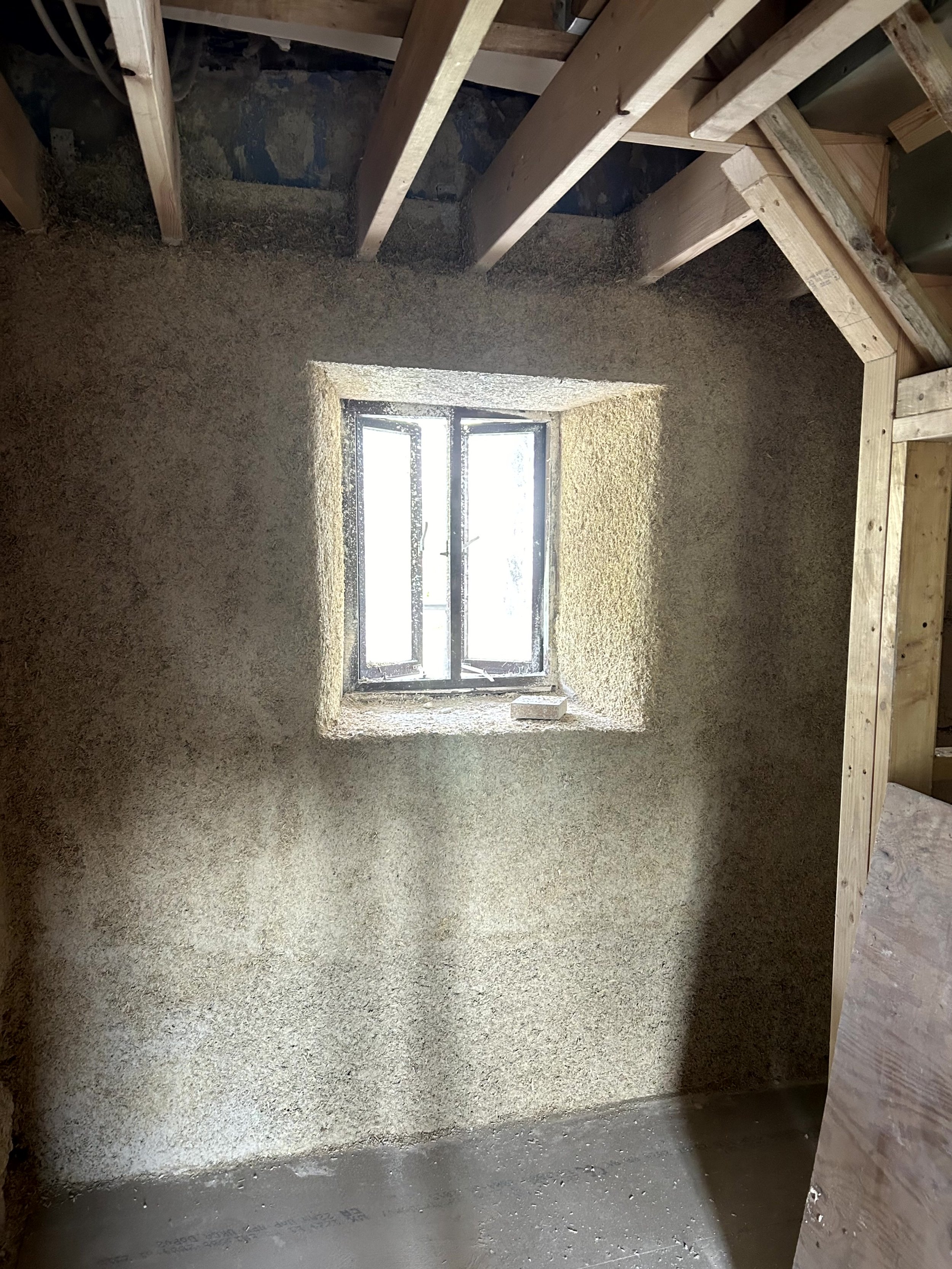 Two-storey timber-frame new build under construction, fully scaffolded, ready for hempcrete between the studs
