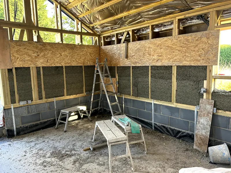 Interior view with the lower walls cast in hempcrete and OSB shuttering fixed above for the next lift